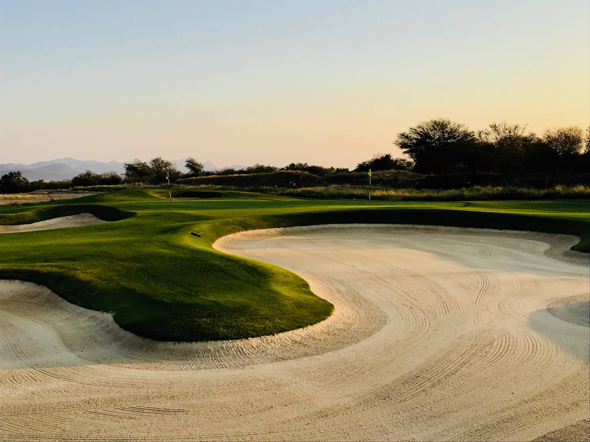 Image of a golf course, bunker and green