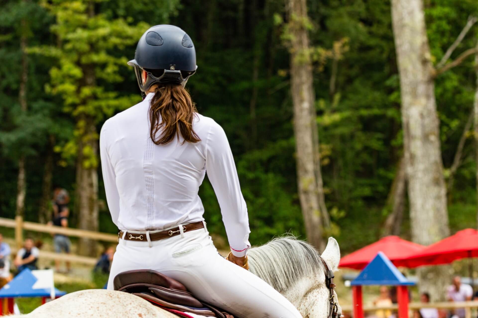 Lady riding a horse wearing a helmet